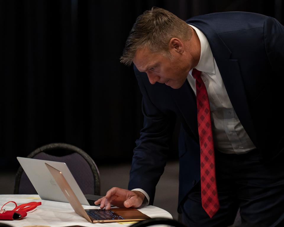Kris Kobach checked early results Tuesday during a Kansas GOP watch party at Hotel Topeka in Topeka. Kobach claimed the win over Democratic challenger Chris Mann early Wednesday.