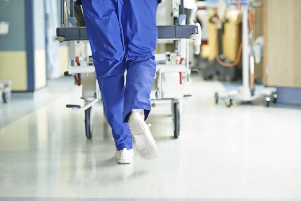 nurse rolling a patients bed down a hospital's halls