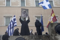 An Orthodox monk holds a representation of the Virgin Mary and child during a clashes in Athens, Sunday, Jan. 20, 2019. Greece's Parliament is to vote this coming week on whether to ratify the agreement that will rename its northern neighbor North Macedonia. Macedonia has already ratified the deal, which, polls show, is opposed by a majority of Greeks. (AP Photo/Yorgos Karahalis)