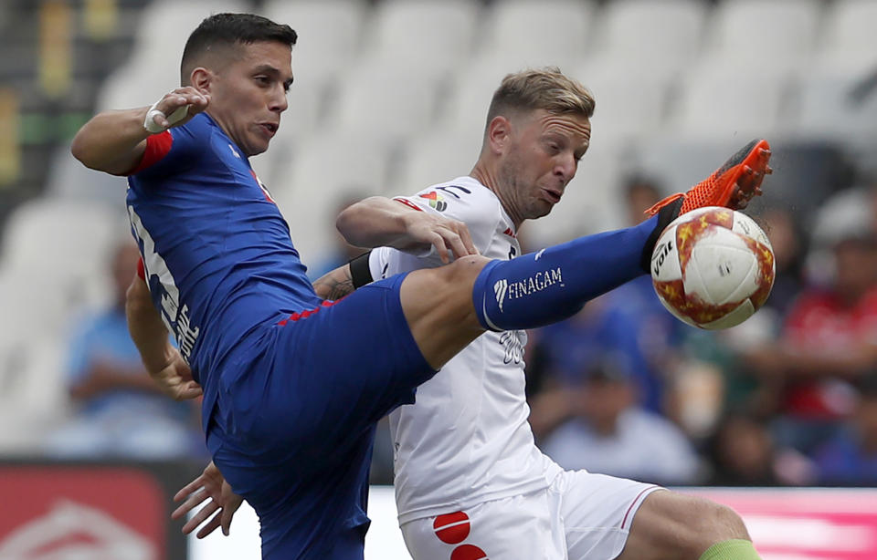In this Sept. 1, 2018 photo, Cruz Azul's Ivan Marcone, left, fights for the ball with Cristian Menendez of Veracruz during a national league soccer match at Azteca Stadium in Mexico City. Cruz Azul won the match 4-1. (AP Photo/Rebecca Blackwell)
