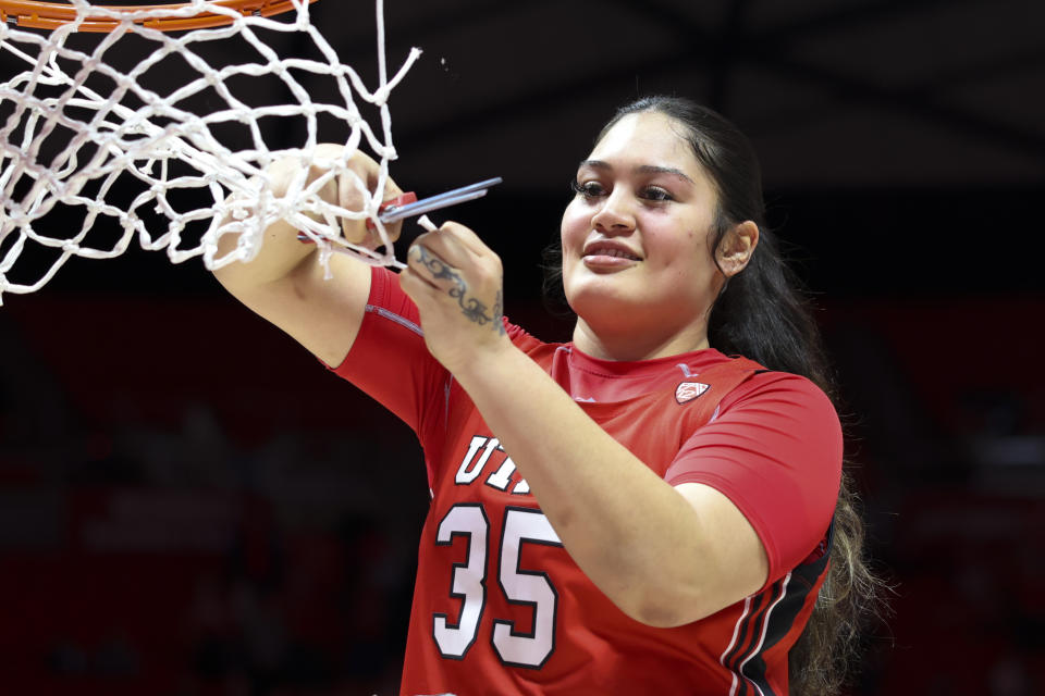 Utah forward Alissa Pili cuts a piece of the net down as co-champions of the Pac-12 on Feb. 25, 2023, in Salt Lake City. (AP Photo/Rob Gray)