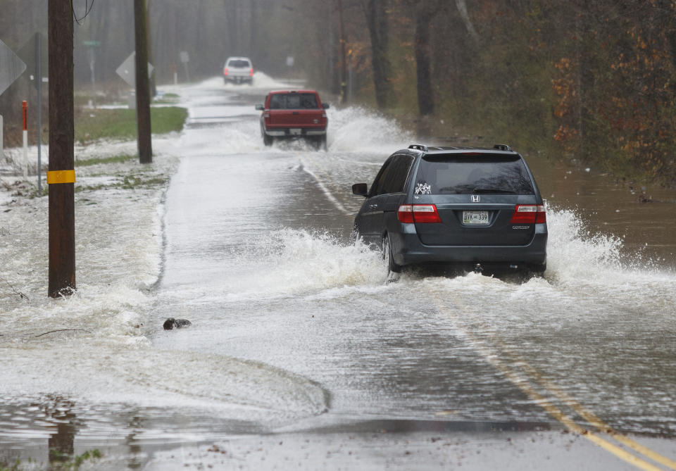 Vehicles travel through floodwaters on Boy Scout Road on Saturday, Feb. 23, 2019, in Soddy-Daisy, Tenn. Area emergency agencies are warning motorists not to attempt to drive through flooded roads. A week of rainfall led to widespread flooding across the Tennessee Valley. (Doug Strickland/Chattanooga Times Free Press via AP)