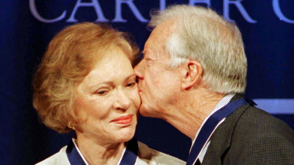 Former President Jimmy Carter kisses former first lady Rosalynn Carter after they received the Presidential Medal of Freedom from President Bill Clinton in 1999. - Tami Chappell/Reuters