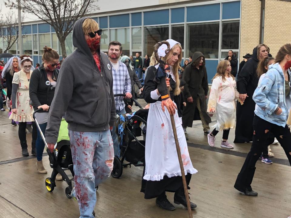 Dressed as a zombie and a pilgrim zombie, Chris Morgan (left) and Jada Morgan marched in the Sioux Falls Zombie Walk in downtown Sioux Falls on Saturday, Oct. 27, 2018.