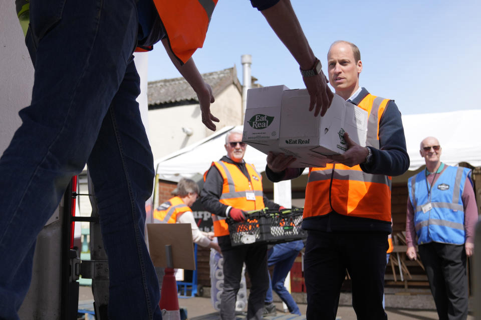 Britain's Prince William helps to loads trays of food into vans during a visit to Surplus to Supper, in Sunbury-on-Thames, Surrey, England, Thursday, April 18, 2024. The Prince visited Surplus to Supper, a surplus food redistribution charity, to learn about its work bridging the gap between food waste and food poverty across Surrey and West London. (AP Photo/Alastair Grant, pool)