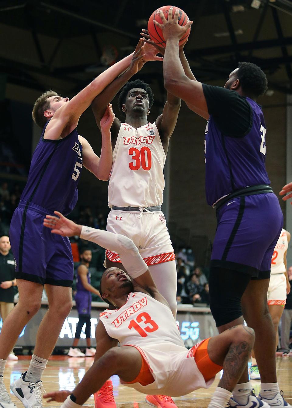 Texas-Rio Grande Valley's RayQuan Taylor (30) and Xavier Johnson (13) battle for the ball against Abilene Christian's Cameron Steele (5) and Airion Simmons (23) during the Western Athletic Conference game Wednesday in Edinburg.