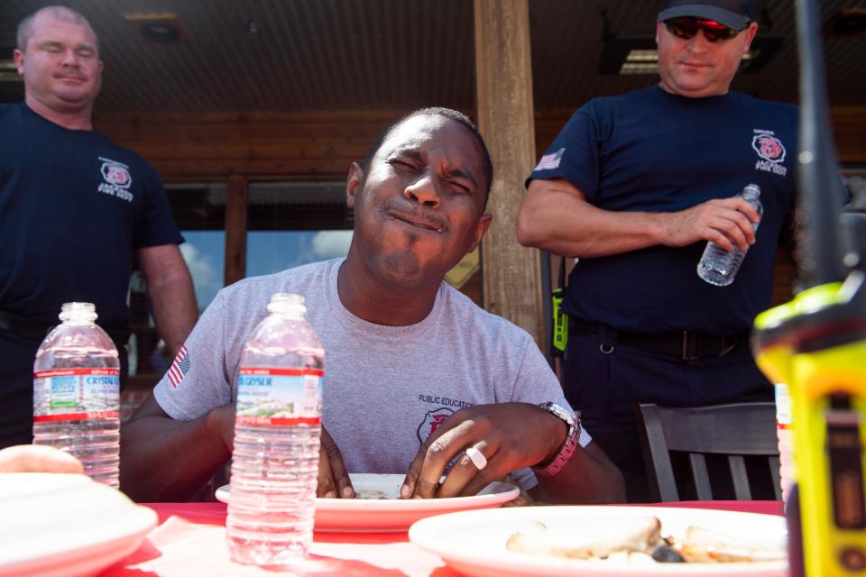 Latrell Billingsley on the firefighter team grimaces while trying to finish his rack of ribs during the Battle of the Badges Rib Eating Contest in which a team from the Jackson Fire Department went up against a team from the Jackson Police Department in a relay to see which team could eat the ribs the fastest at Texas Roadhouse on Monday, August 22, 2022, in Jackson, Tenn. The event was to promote the Dine to Donate fundraising night at Texas Roadhouse on Monday, August 29, where ten percent of the total food purchases will go towards the Carl Perkins Exchange Club.