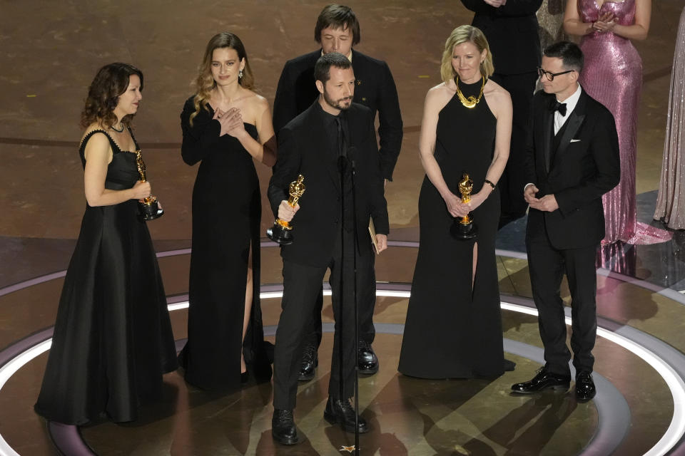 Raney Aronson-Rath, from left, Vasilisa Stepanenko, Mstyslav Chernov, Evgeniy Maloletka, Michelle Mizner, and Derl McCrudden accept the award for best documentary feature film for "20 Days in Mariupol" during the Oscars on Sunday, March 10, 2024, at the Dolby Theatre in Los Angeles. (AP Photo/Chris Pizzello)