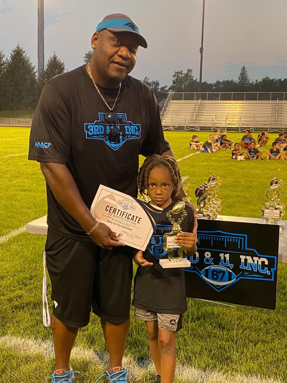 Brandon Hayes (left), former NFL lineman, Muncie Southside High School graduate and founder of 3rd & 11 Inc., congratulates one of the first-place winners of the organization's football combine events.