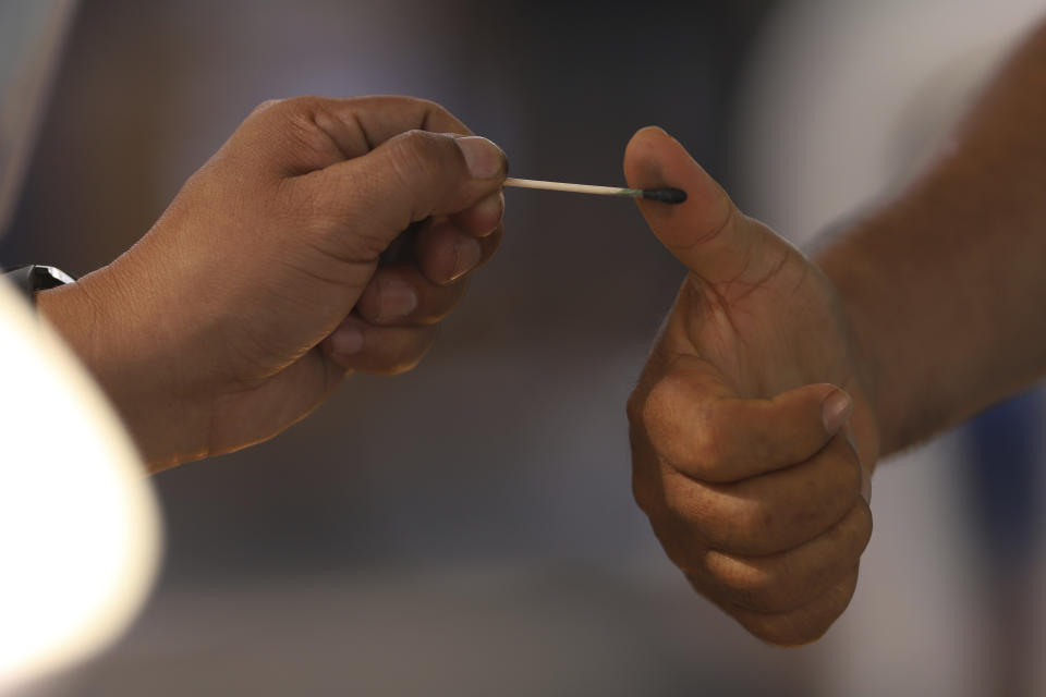 A voter has his thumb marked after voting in legislative and local elections, at a polling place in San Salvador, El Salvador, Sunday, Feb. 28, 2021. Sunday's elections in El Salvador are seen as a referendum on whether to break the congressional deadlock that has tied the hands of upstart populist President Nayib Bukele. (AP Photo/Salvador Melendez)