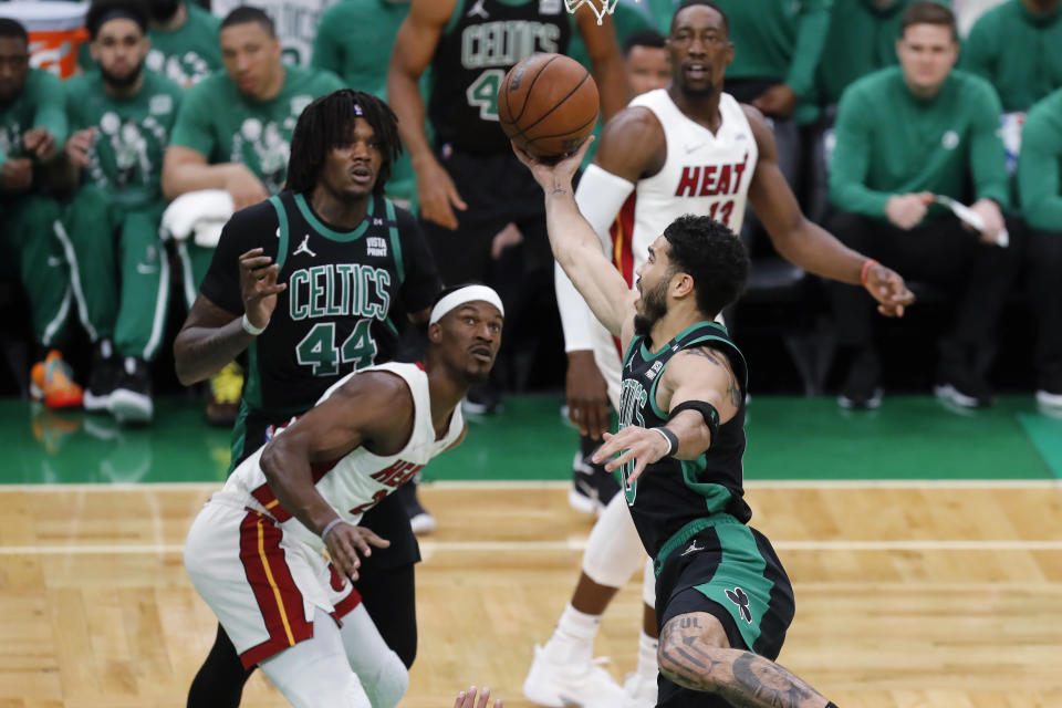 Boston Celtics' Jayson Tatum (0) shoots against Miami Heat's Jimmy Butler (22) during the first half of Game 6 of the NBA basketball playoffs Eastern Conference finals Friday, May 27, 2022, in Boston. (AP Photo/Michael Dwyer)