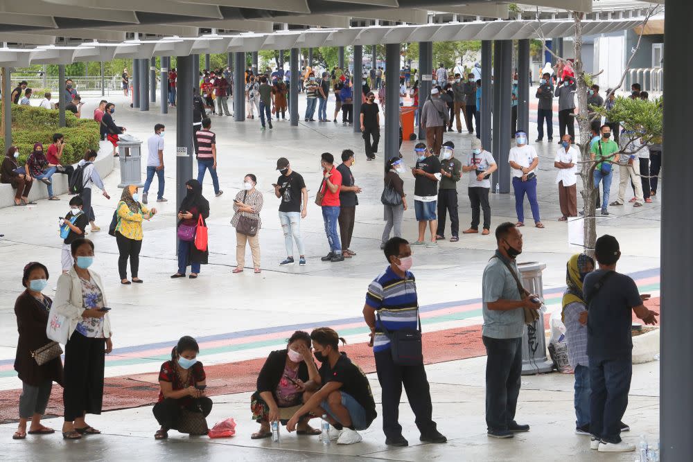 Foreign workers queue as they wait to get their Covid-19 jab at the Bukit Jalil Stadium vaccination centre August 10, 2021. ― Picture by Choo Choy May