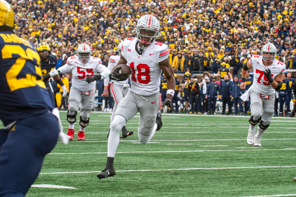 ANN ARBOR, MICHIGAN - NOVEMBER 25: Marvin Harrison Jr. #18 of the Ohio State Buckeyes runs with the ball for a touchdown during the second half of a college football game against the Michigan Wolverines at Michigan Stadium on November 25, 2023 in Ann Arbor, Michigan. The Michigan Wolverines won the game 30-24 to win the Big Ten East. (Photo by Aaron J. Thornton/Getty Images)
