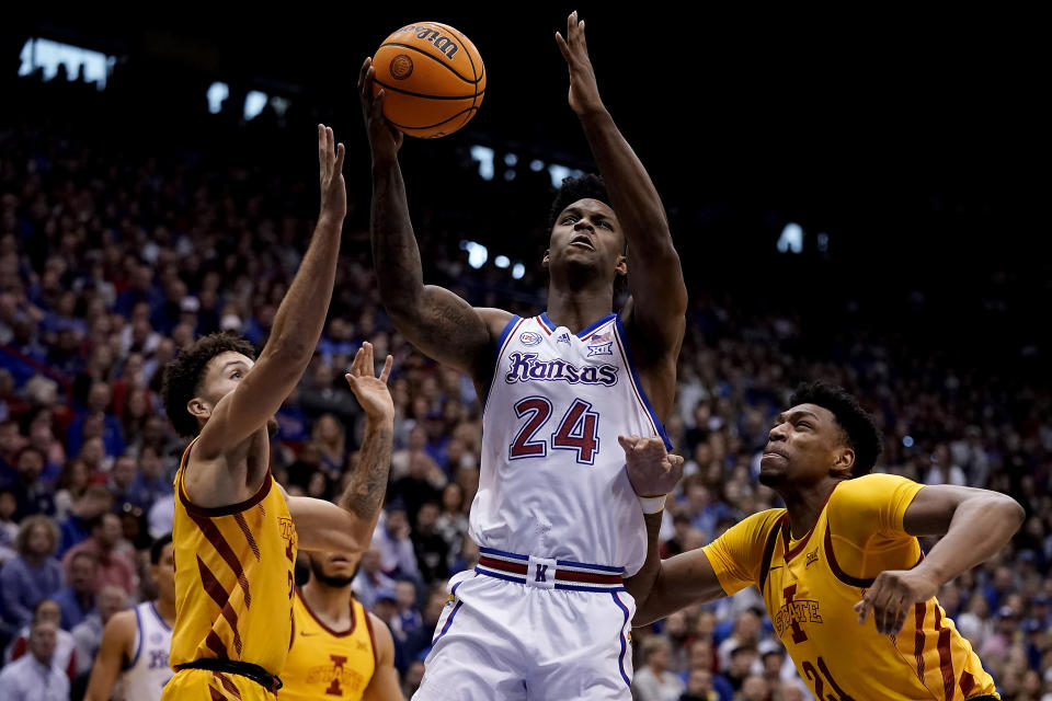 Kansas forward K.J. Adams Jr. (24) shoots between Iowa State guard Gabe Kalscheur, left, and center Osun Osunniyi (21) during the first half of an NCAA college basketball game Saturday, Jan. 14, 2023, in Lawrence, Kan. (AP Photo/Charlie Riedel)