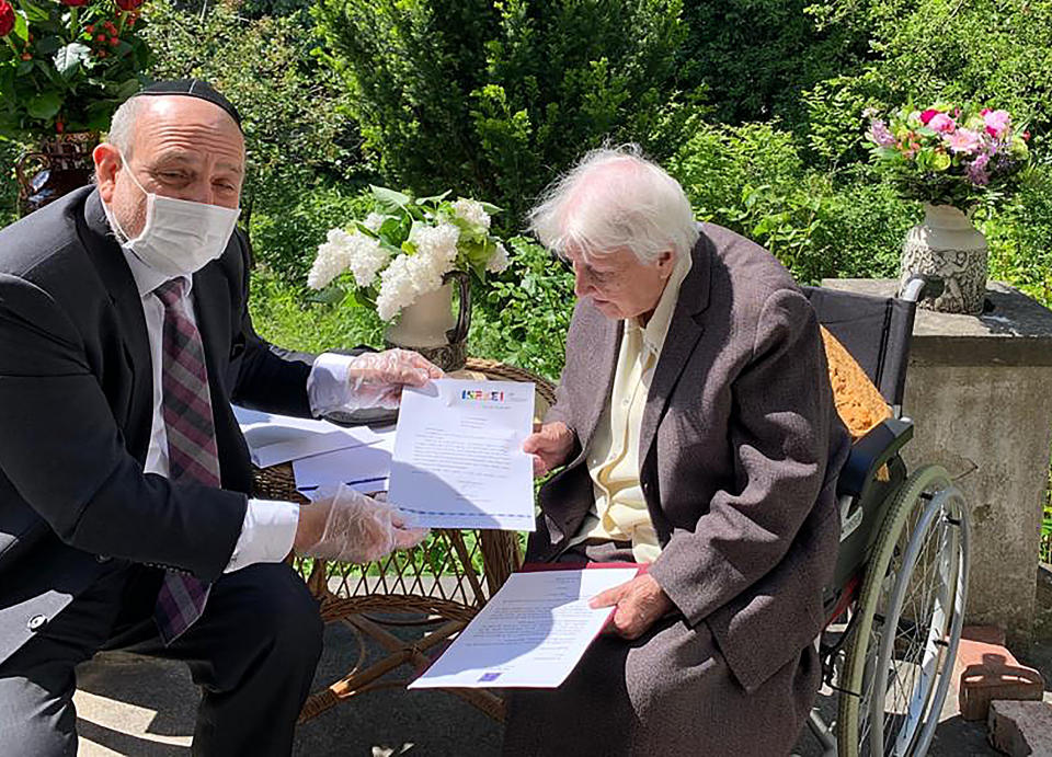 Poland's chief rabbi, Michael Schudrich, delivers letters with birthday greetings from the Israeli and Polish presidents, to Anna Kozminska, a 101-year-old Polish woman who is believed to the be oldest living person recognized by Yad Vashem for rescuing Jews during the Holocaust, in Warsaw, Poland, on Friday, May 22, 2020. Both Reuven Rivlin of Israel and Andrzej Duda of Poland praised Kozminska in letters for her courage in risking her own life help Jews during the German occupation of Poland. (Grazyna Pawlak via AP)