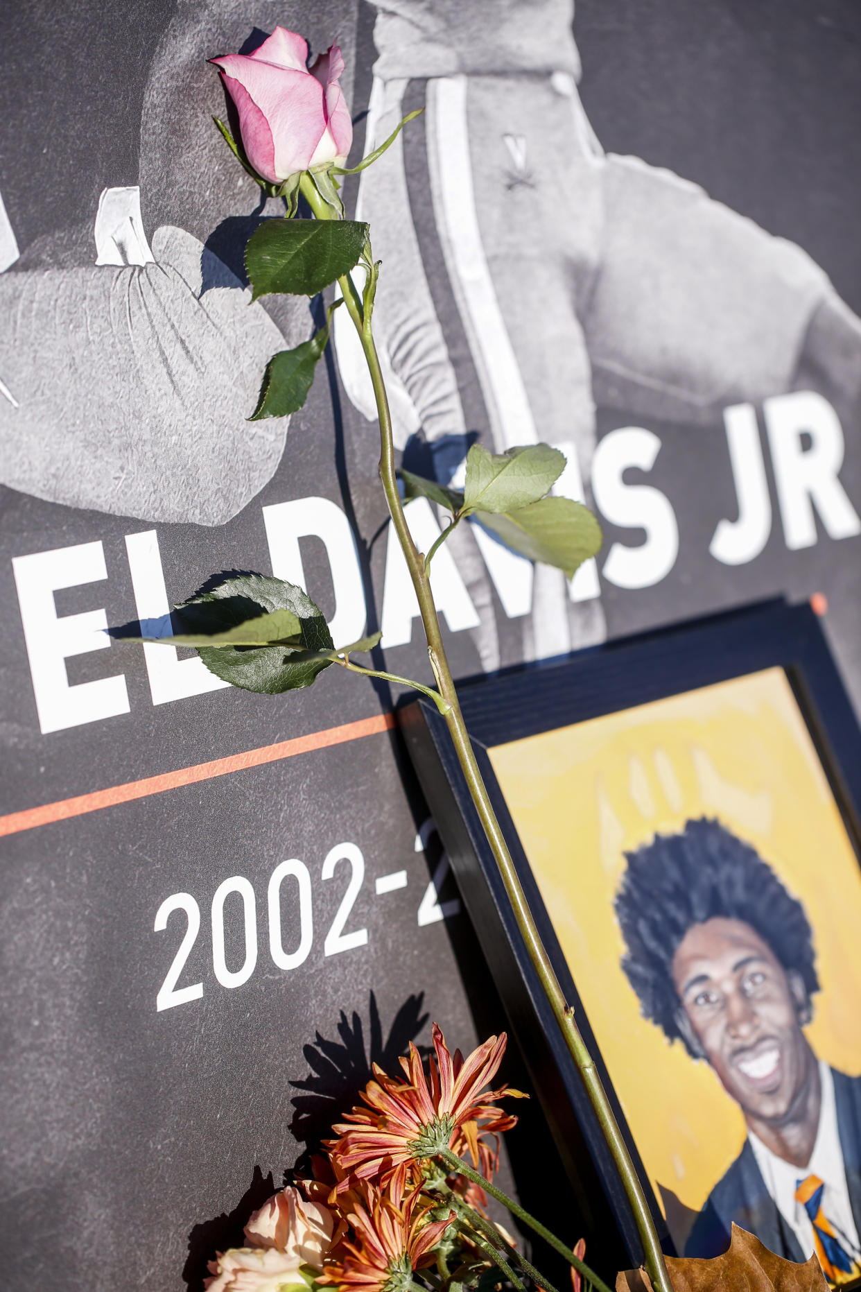 A flower lies next to a picture of Lavel Davis Jr. during a memorial service on Saturday, Nov. 19, 2022, at John Paul Jones Arena on the campus of the University of Virginia in Charlottesville, Va. On Sunday, Nov. 13, University of Virginia football players from Devin Chandler, Lavel Davis Jr. and D'Sean Perry were shot and killed by a teammate following a school field trip to Washington. (Shaban Athuman/Richmond Times-Dispatch via AP)