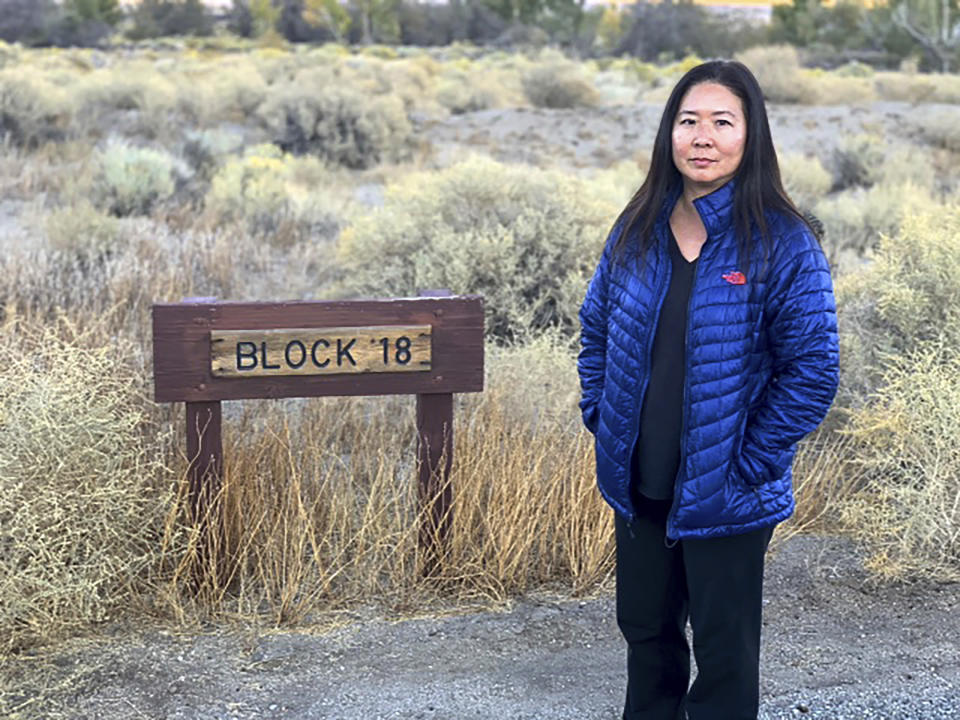 In this Nov. 1, 2019 photo, Lori Matsumura poses in front of the block where her father and grandparents lived at the Manzanar, Calif., internment camp during World War II. Matsumura provided the DNA sample to identify the remains of her grandfather, who died while hiking in the mountains near the end of the war. His partly unearthed gravesite was discovered by hikers in October and his skeleton was retrieved by the Inyo County Sheriff's Office. The sheriff said on Friday, Jan. 3, 2020 that the DNA test proved the remains were of Matsumura. (Thomas Storesund via AP).