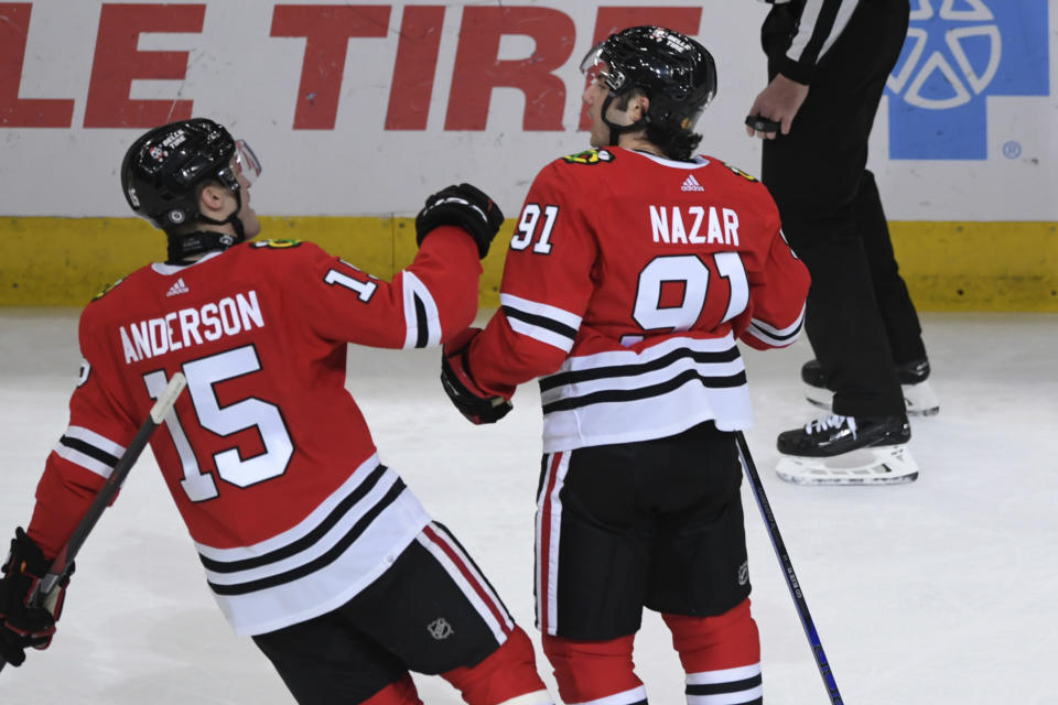 Chicago Blackhawks' Frank Nazar (91) celebrates with teammate Joey Anderson (15) after scoring his first goal in the NHL during the first period of a hockey game against the Carolina Hurricanes, Sunday, April 14, 2024, in Chicago. (AP Photo/Paul Beaty)