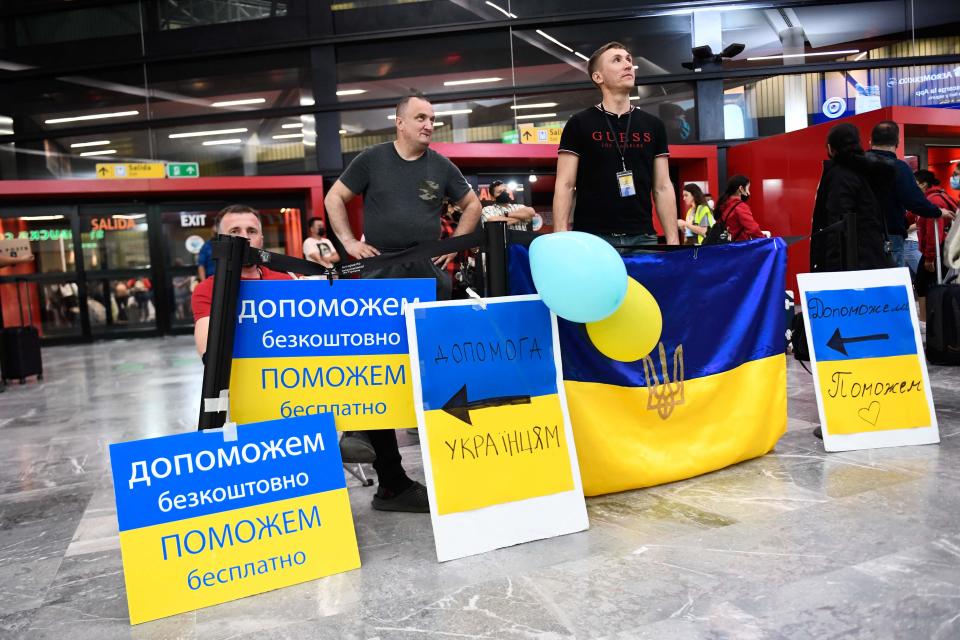 Volunteers with signs welcome Ukrainian refugees as they arrive at the Tijuana airport to help them on their journey to the United States after fleeing the war in Ukraine, in Tijuana, Baja California state, Mexico on on April 8, 2022.