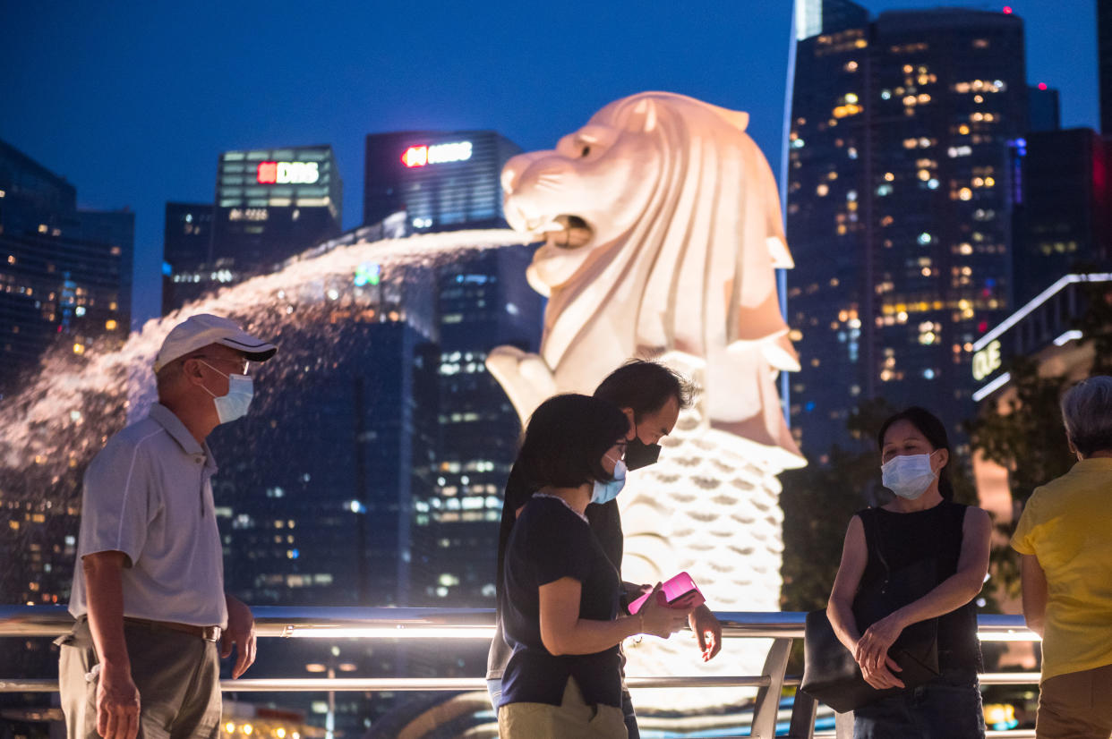 Vistors walk past the Merlion at the Marina Bay on 18 July, 2021. (PHOTO: Getty Images)