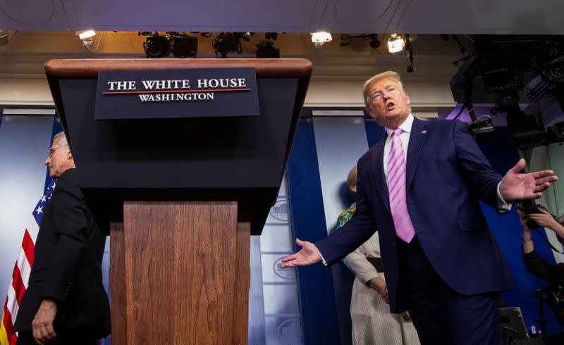 President Donald Trump takes the podium as Dr. Anthony Fauci walks away after addressing the daily coronavirus response briefing at the White House in Washington