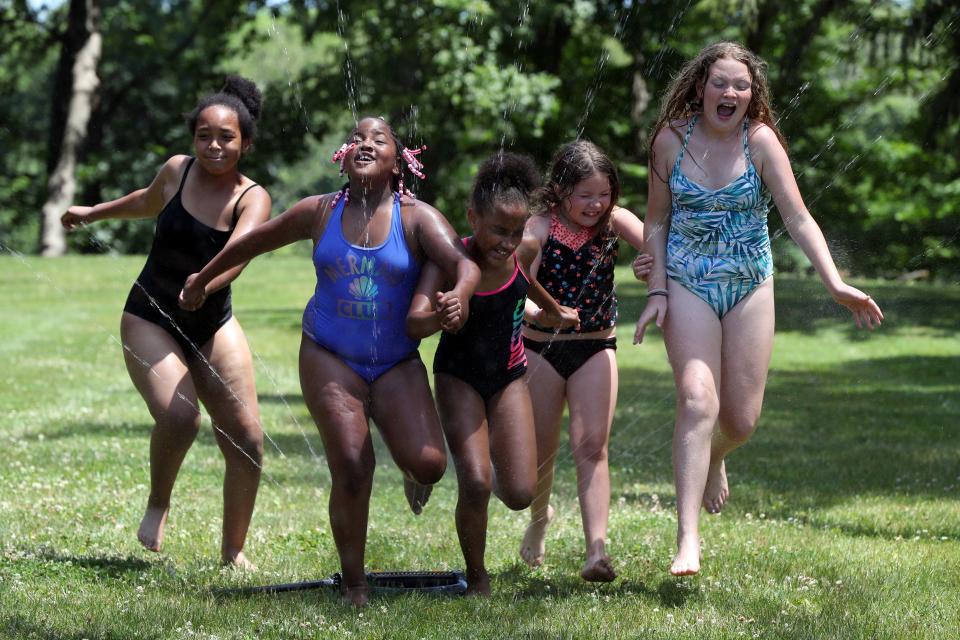 Campers cool off with a run through the sprinklers during the 2021 summer day camp at the Whitehall Community Park YMCA.