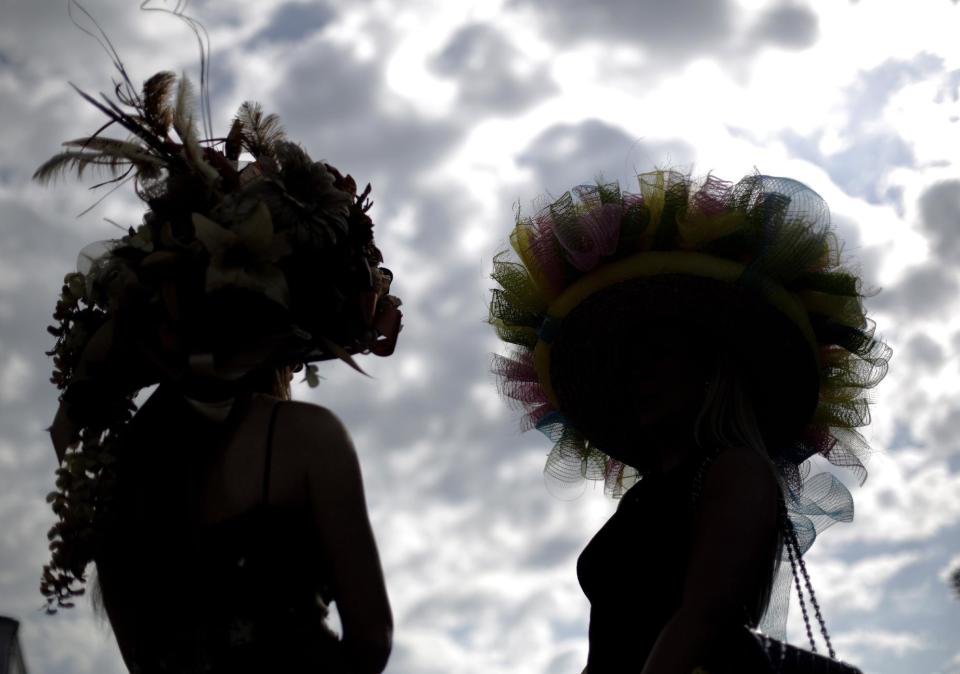 Ashley Cebak and Tami Purcell wear hats before the 140th running of the Kentucky Derby horse race at Churchill Downs Saturday, May 3, 2014, in Louisville, Ky. (AP Photo/David Goldman)