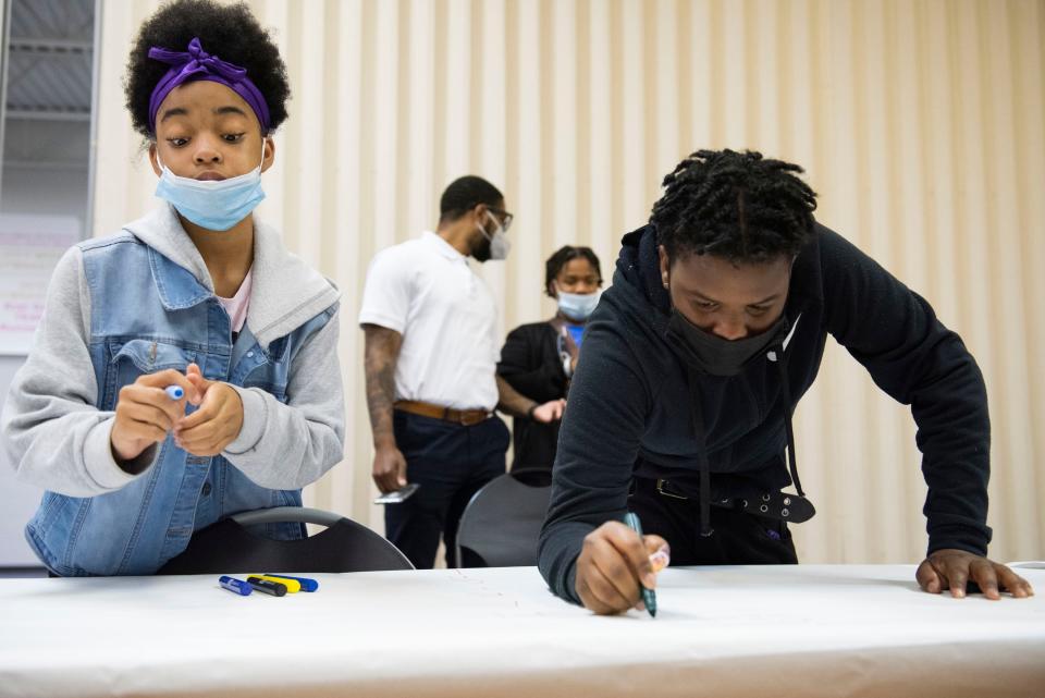 D’Vayah Vaughn, 13, (left) and Damari Parker-Morris, 13, write their personal, academic and social goals Nov. 10.