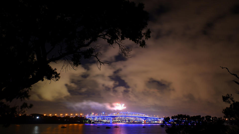 Fireworks are seen exploding from the Sky Tower with the Auckland Harbour Bridge in the foreground during the Auckland New Year's Eve celebrations on January 01, 2019 in Auckland, New Zealand.