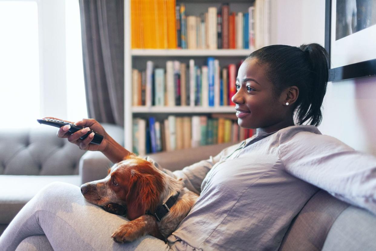 woman watching Halloween movies with her dog