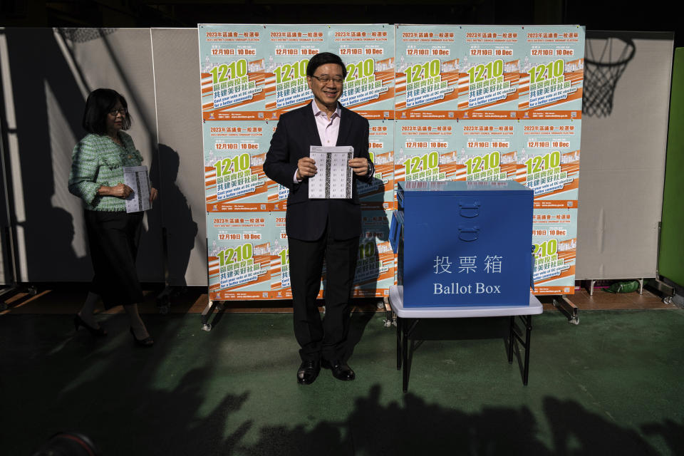 Hong Kong's Chief Executive John Lee and his wife Janet Lam, left, cast their ballot at a polling station during the District Council elections in Hong Kong, Sunday, Dec. 10, 2023. Residents went to the polls on Sunday in Hong Kong's first district council elections since an electoral overhaul was implemented under Beijing's guidance of “patriots” administering the city, effectively shutting out all pro-democracy candidates.(AP Photo/Louise Delmotte)