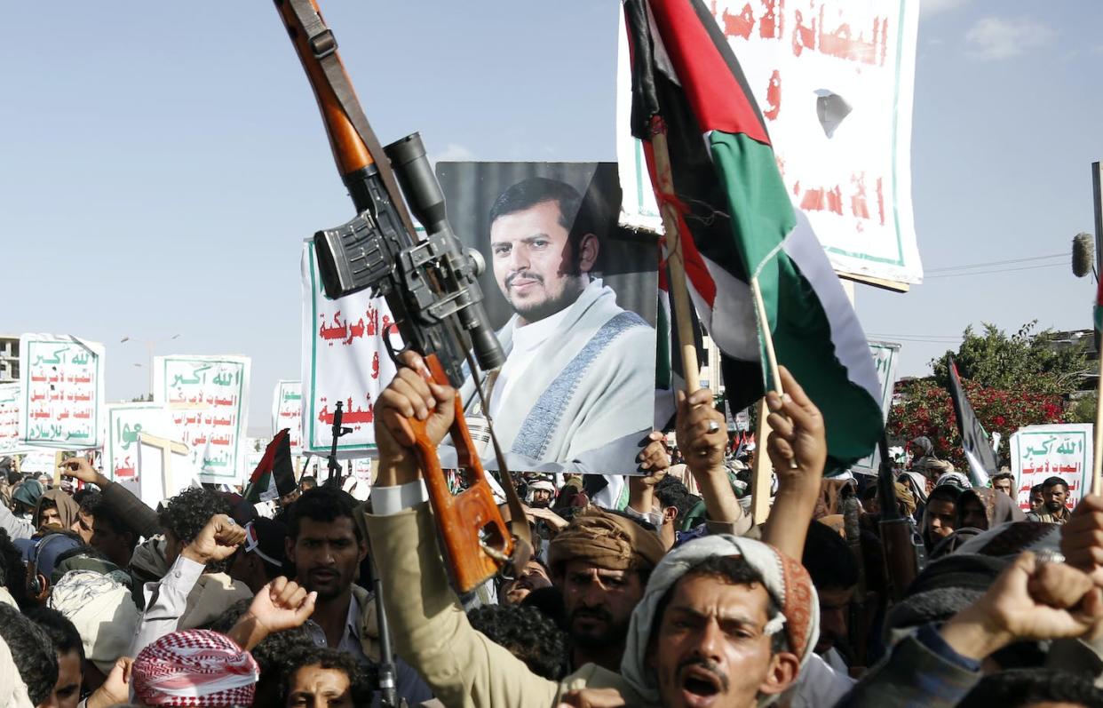A poster of rebel leader Abdul-Malek al-Houthi is held aloft during anti-Israel protests in Yemen. <a href="https://www.gettyimages.com/detail/news-photo/yemens-houthi-supporters-hold-banners-and-flags-as-they-news-photo/1745360875?adppopup=true" rel="nofollow noopener" target="_blank" data-ylk="slk:Mohammed Hamoud/Getty Images;elm:context_link;itc:0;sec:content-canvas" class="link ">Mohammed Hamoud/Getty Images</a>
