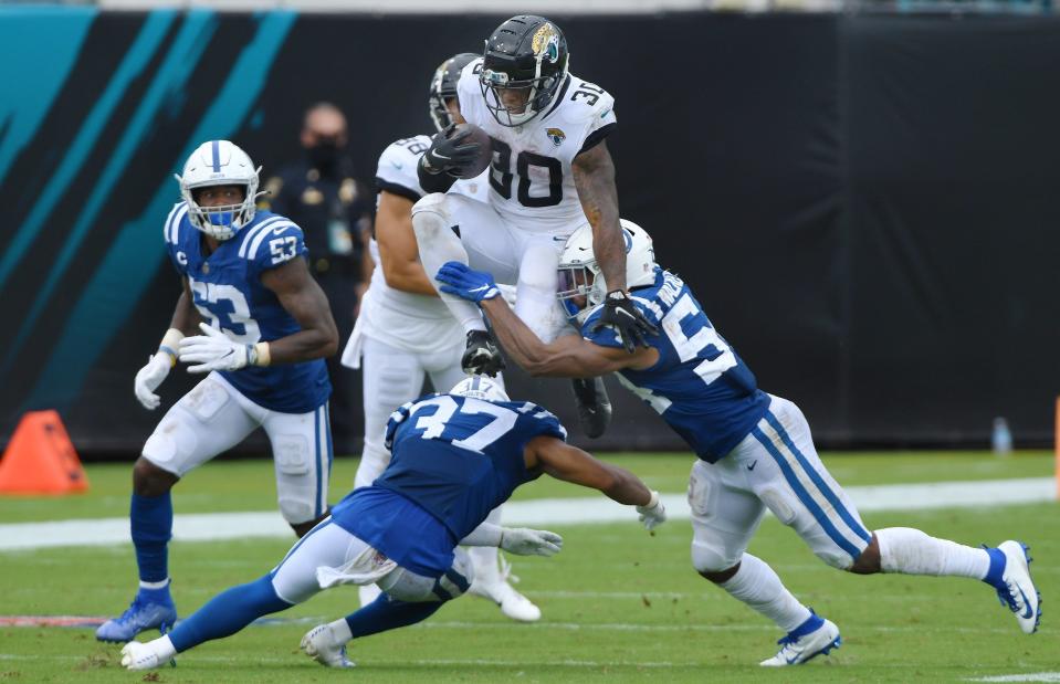 Jacksonville Jaguars running back James Robinson (30) hurdles Colts defenders as he picks up yardage during a fourth quarter play. The Jaguars came away with a 27-20 victory against the Indianapolis Colts in the season opening game at TIAA Bank Field Sunday, September 13, 2020. [Bob Self/Florida Times-Union]