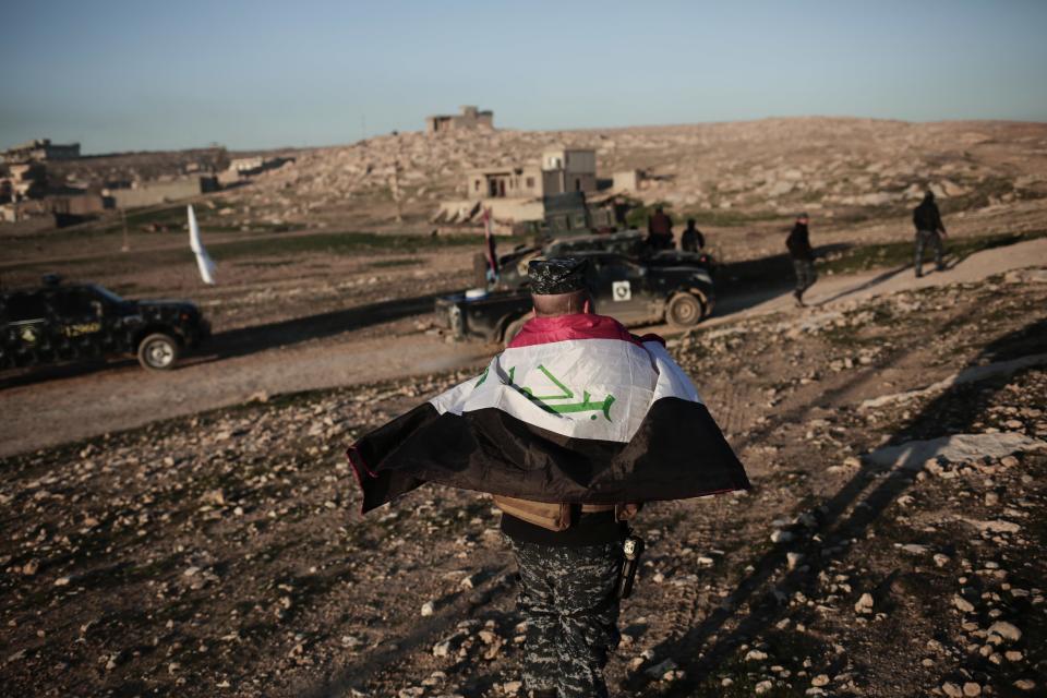 A member of the Iraqi federal police wears an Iraqi flag around his shoulders before going to battle against the Islamic State group, in Hamam al-Alil, Iraq, Sunday, Feb. 2017. U.S.-backed Iraqi forces launched a large-scale military operation on Sunday to dislodge Islamic State militants from the western half of Mosul city. (AP Photo/Bram Janssen)