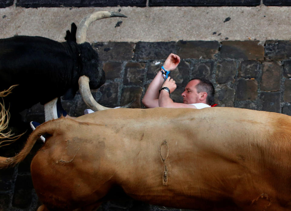 <p>A runner falls under Cebada Gago bulls during the first running of the bulls at the San Fermin festival in Pamplona, northern Spain, July 7, 2017. (Joseba Etxaburu/Reuters) </p>