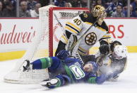 Vancouver Canucks' Tyler Motte, bottom left, crashes into Boston Bruins goalie Tuukka Rask (40), of Finland, after being taken down by Patrice Bergeron during the first period of an NHL hockey game Saturday, Feb. 22, 2020, in Vancouver, British Columbia. (Darryl Dyck/The Canadian Press via AP)