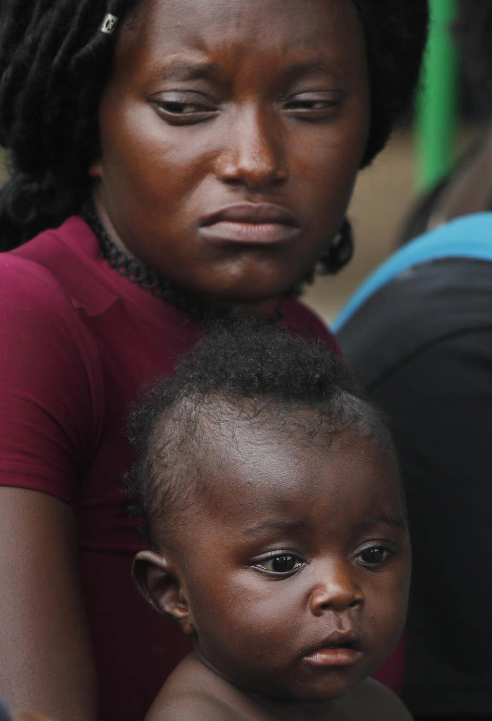 A Haitian migrant mother and son wait in line to solve their migratory situation at an immigration center in Tapachula, Chiapas state, Mexico, Monday, June 3, 2019. New immigration routes for Cubans, Haitians and people from Africa have opened up through Central America. (AP Photo/Marco Ugarte)