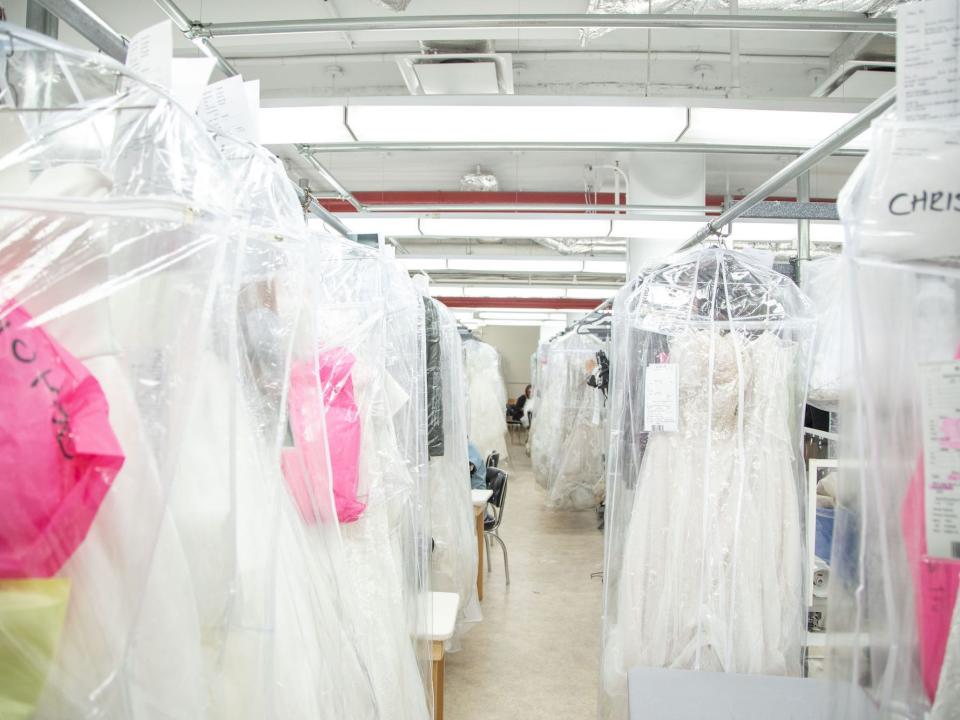 A large room with wedding dresses on hangers.