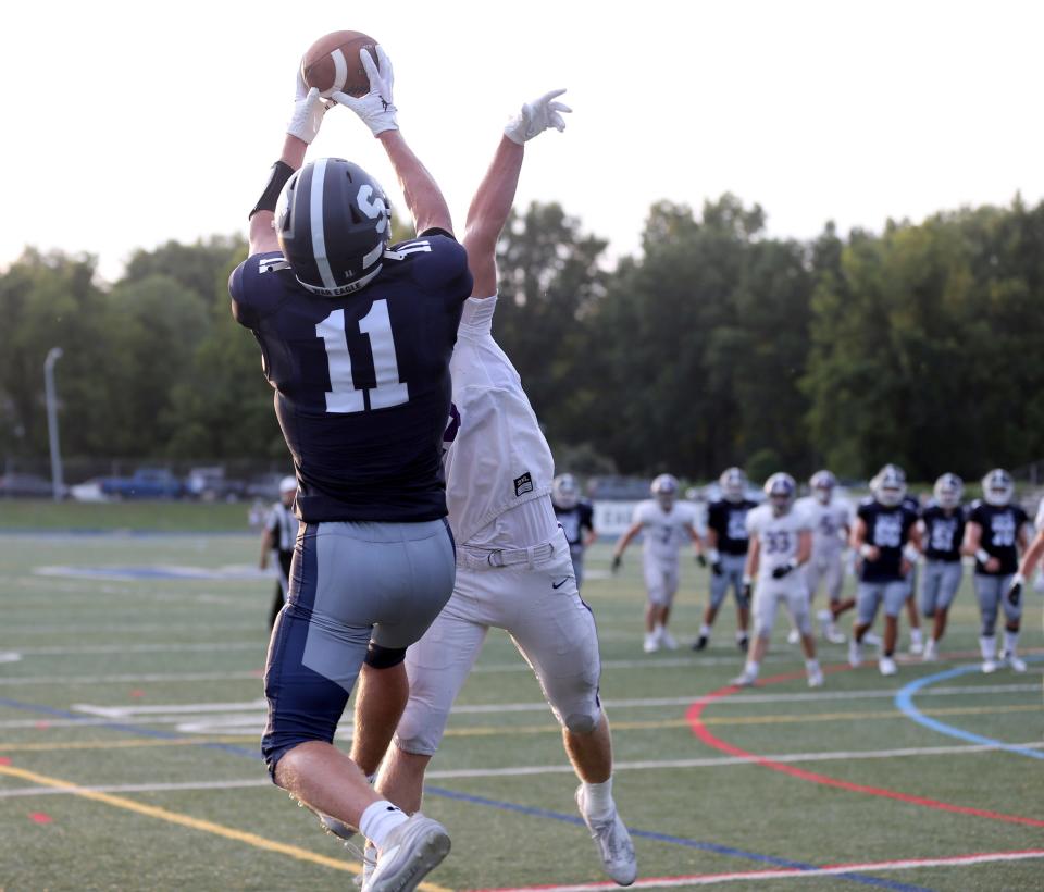 Under pressure from Rumson-Fair Haven's Gavin Kiley, Middletown South's Owen Richter pulls in the ball at the goal lines for South's first touchdown Friday evening, August 25, 2023.