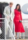 <p>Meghan had a quick change on the plane and arrived Tonga wearing a <a href="https://www.townandcountrymag.com/style/fashion-trends/a24183870/meghan-markle-white-theia-gown-dinner-tonga-photo/" rel="nofollow noopener" target="_blank" data-ylk="slk:red midi-length dress;elm:context_link;itc:0;sec:content-canvas" class="link ">red midi-length dress</a> by Self Portrait paired with a black clutch and pumps.</p>