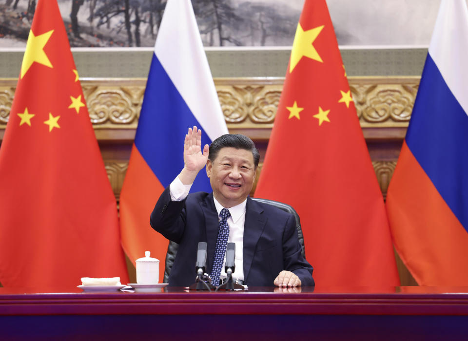 In this photo released by Xinhua News Agency, Chinese President Xi Jinping waves as he witnesses the ground-breaking ceremony of a bilateral nuclear energy cooperation project, Tianwan nuclear power plant and Xudapu nuclear power plant, via video link with his Russian counterpart Vladimir Putin from Beijing, Wednesday, May 19, 2021. The Chinese leader and his Russian counterpart joined in a videoconference to initiate a series of nuclear energy projects, an event intended to display warming ties between two nations that have paired-up as the chief geopolitical rivals to the United States. (Huang Jingwen/Xinhua via AP)