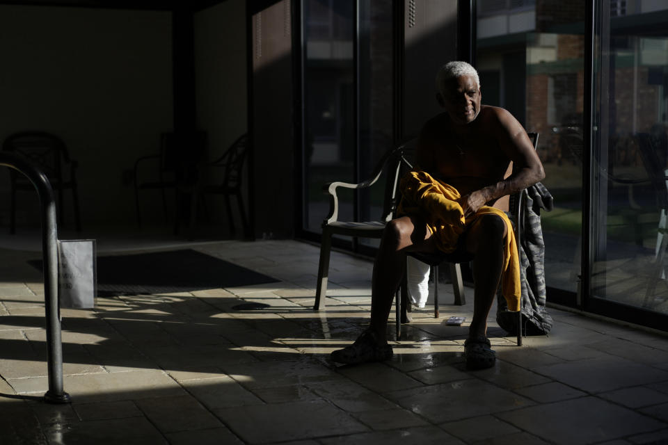 Study participant Reynold Guppy, visiting from Florida, sits by a pool after swimming among submerged BioHealing generators at the Tesla Wellness Hotel and MedBed Center on Wednesday, Nov. 15, 2023, in Butler, Pa. (AP Photo/Carolyn Kaster)