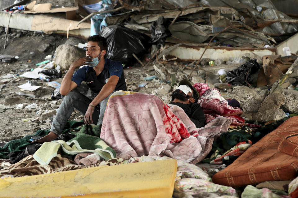 Protesters rest under the Joumhouriya Bridge, that leads to the Green Zone where many government offices and embassies are located, during ongoing anti-government protests, in Baghdad, Iraq, Sunday, Nov. 3, 2019. (AP Photo/Hadi Mizban)