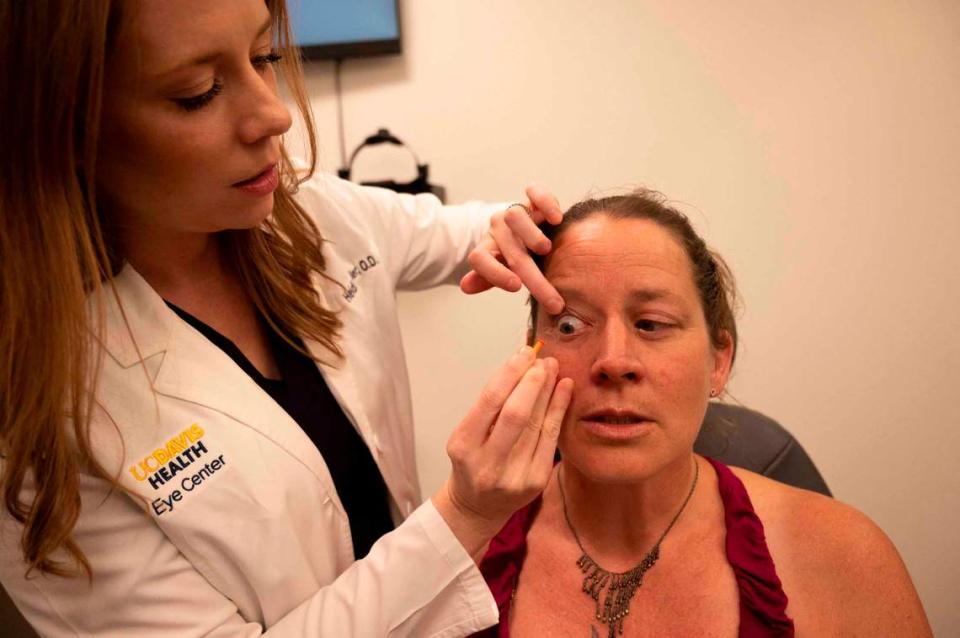 Optometrist Heidi Miller takes out a corrective lens during an exam with one of her Medi-Cal patients, Angela DeWalt, at the UC Davis Tschannen Eye Center on May 23.