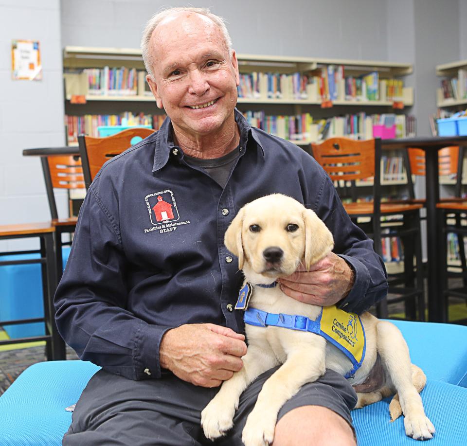 Mike Hartsky, who works at North Star Elementary School, raises puppies for Canine Companions. He is raising his 22nd service dog – a 3-month-old golden retriever-Labrador mix named Scooby II.