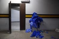 Used security gear worn in the COVID-19 area overflows a trash can at Clinicas Hospital in San Lorenzo, Paraguay, Tuesday, April 20, 2021. (AP Photo/Jorge Saenz)