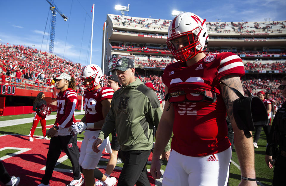 Nebraska head coach Scott Frost, second right, exits the field with Oliver Martin (89) and Tate Wildeman (92) following their 26-17 loss to Ohio State in an NCAA college football game Saturday, Nov. 6, 2021, at Memorial Stadium in Lincoln, Neb. (AP Photo/Rebecca S. Gratz)