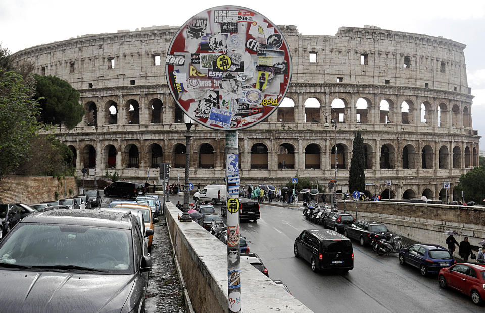 A street sign on a road leading to the ancient Colosseum is covered in stickers, in Rome, Monday, Nov. 5, 2018. Rome’s monumental problems of garbage and decay exist side-by-side with Eternal City’s glories. (AP Photo/Gregorio Borgia)