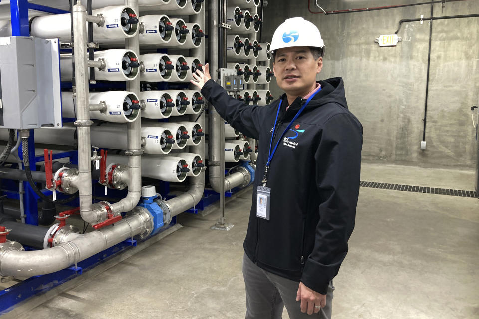 Sunny Wang, water resources manager for Santa Monica, gestures toward reverse osmosis membranes used to purify storm and sewer water on Tuesday, Jan. 17, 2023, in Santa Monica, Calif. In Santa Monica, the new water project captured nearly 2 million gallons (7,600 cubic meters) of runoff that once treated gets used for plumbing, irrigation or pumped back into the city’s aquifer. Wang said the project will eventually save an average of about 40 million gallons (151,000 cubic meters) per year. (AP Photo/Brian Melley)