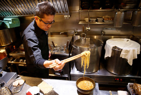 Kenji Saito cooks at his ramen noodle shop in Tokyo, Japan April 12, 2019. Picture taken April 12, 2019. REUTERS/Kim Kyung-hoon